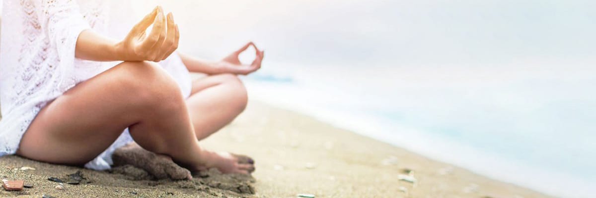 Woman Meditating on the Beach